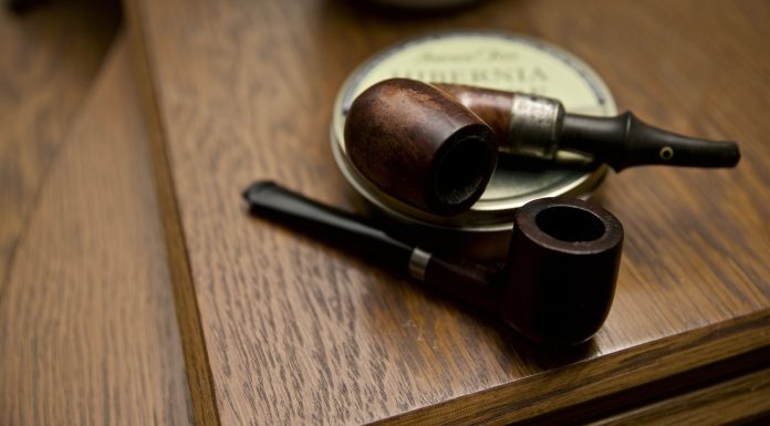The Pipe two black and brown wooden smoking pipes on table