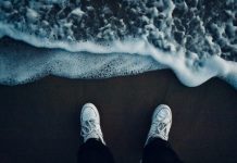 Všetko najlepšie! person in black pants and white sneakers standing on brown sand