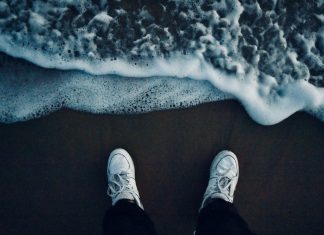 Všetko najlepšie! person in black pants and white sneakers standing on brown sand