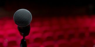 The Woman I Always Knew I Could Be a microphone on a stand in front of a red background